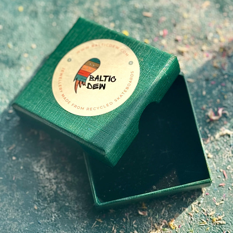 Green jewelry box with a 'Baltic Dew' label on a textured surface