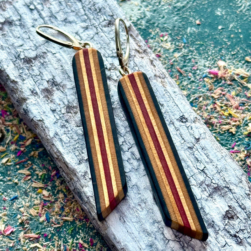 Wooden striped earrings on a textured surface
