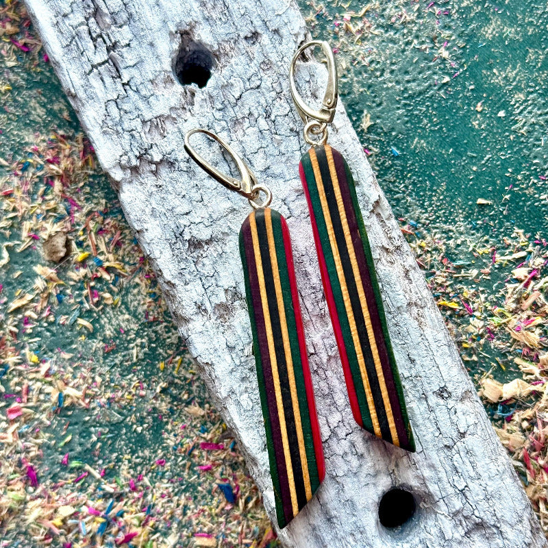 Striped earrings on a textured surface with a natural background