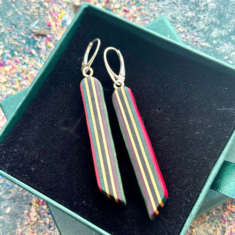 Striped earrings in a green box with a colorful background