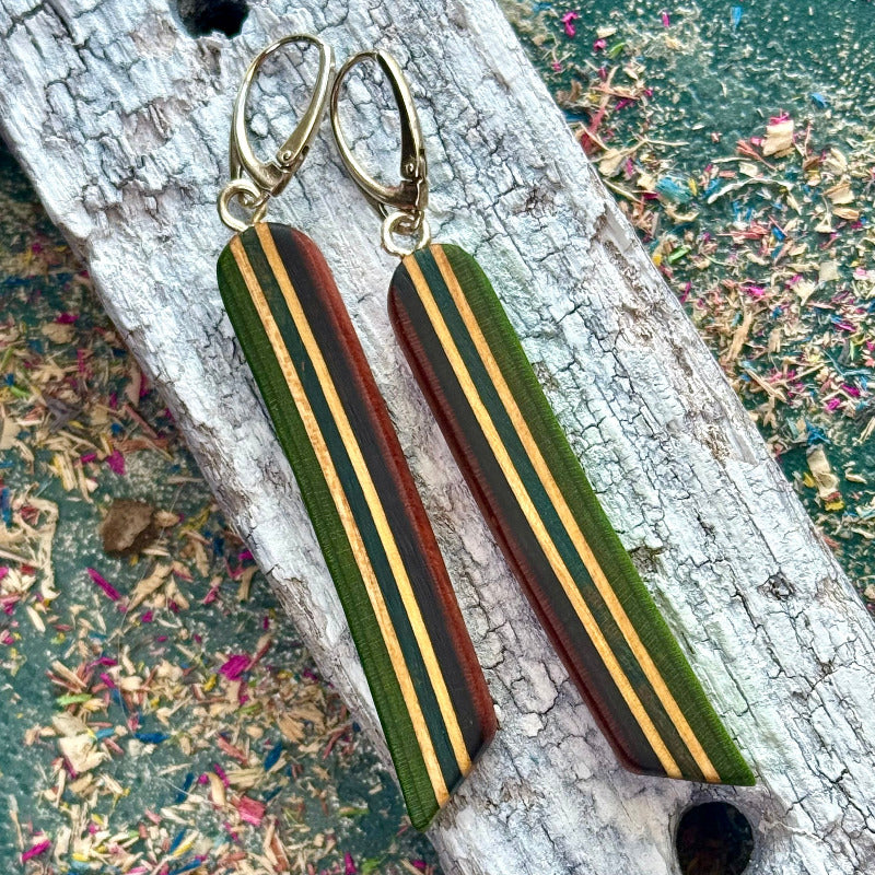Striped earrings on a textured surface with a colorful background