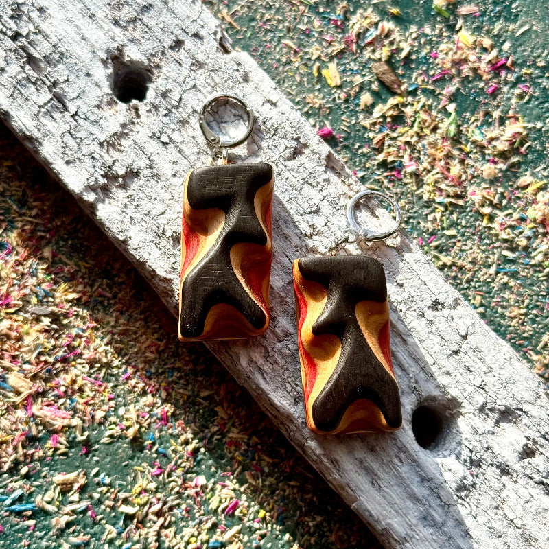 Pair of abstract earrings on a textured surface