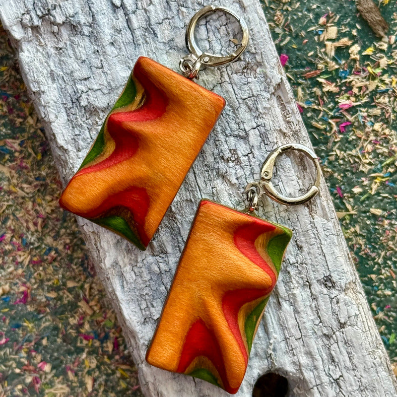 Pair of star-shaped earrings on a wooden surface with a natural background