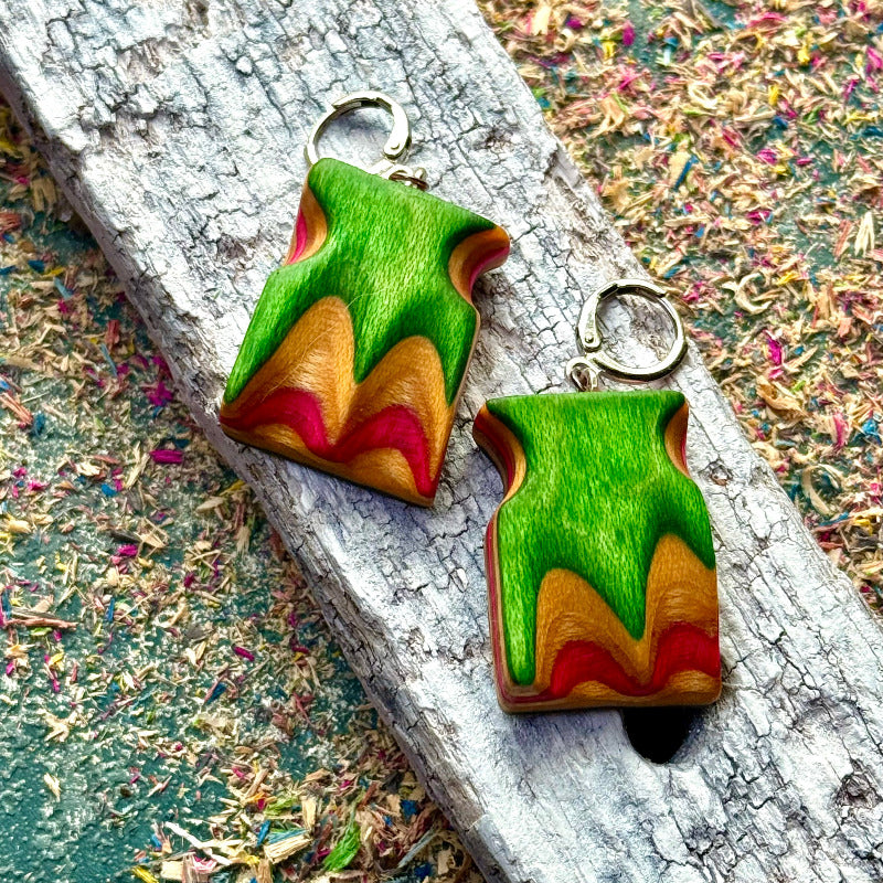 Colorful wooden earrings on a textured surface
