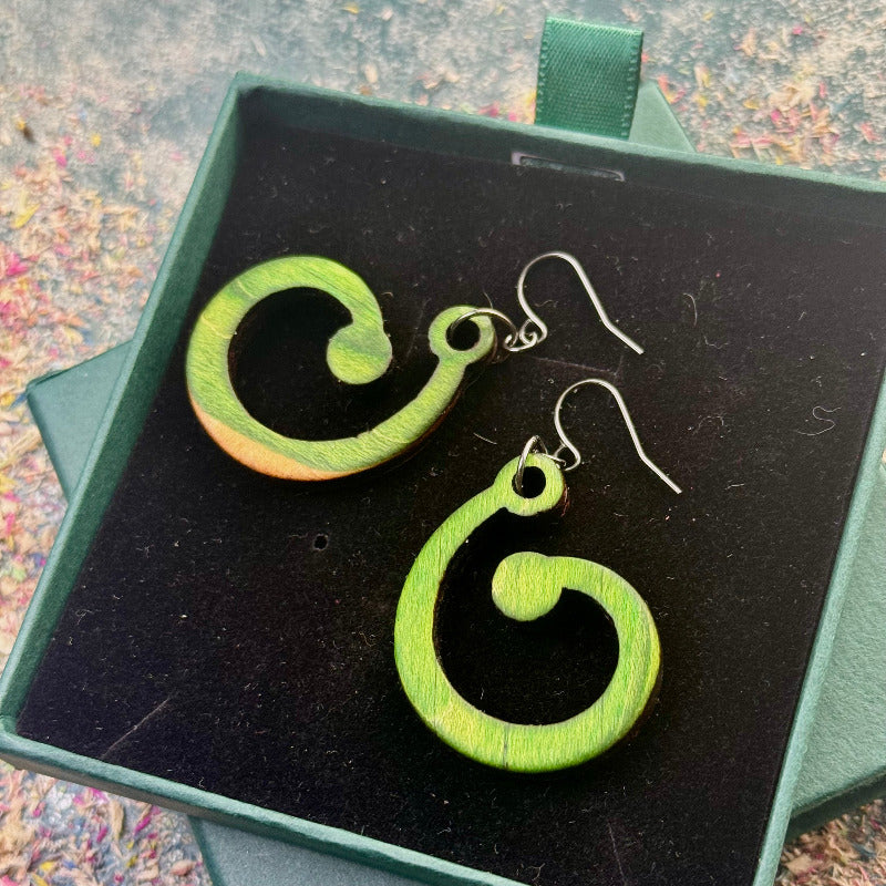 Green spiral earrings in a black jewelry box