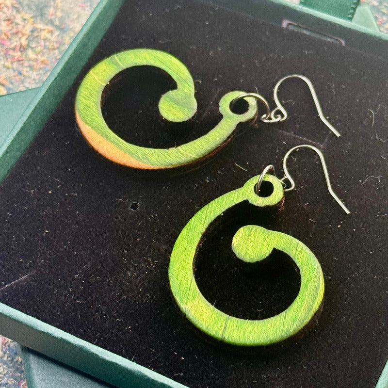 Green wooden earrings on a black display box