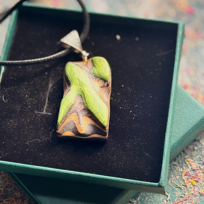 Green and brown pendant on a black background inside a green box
