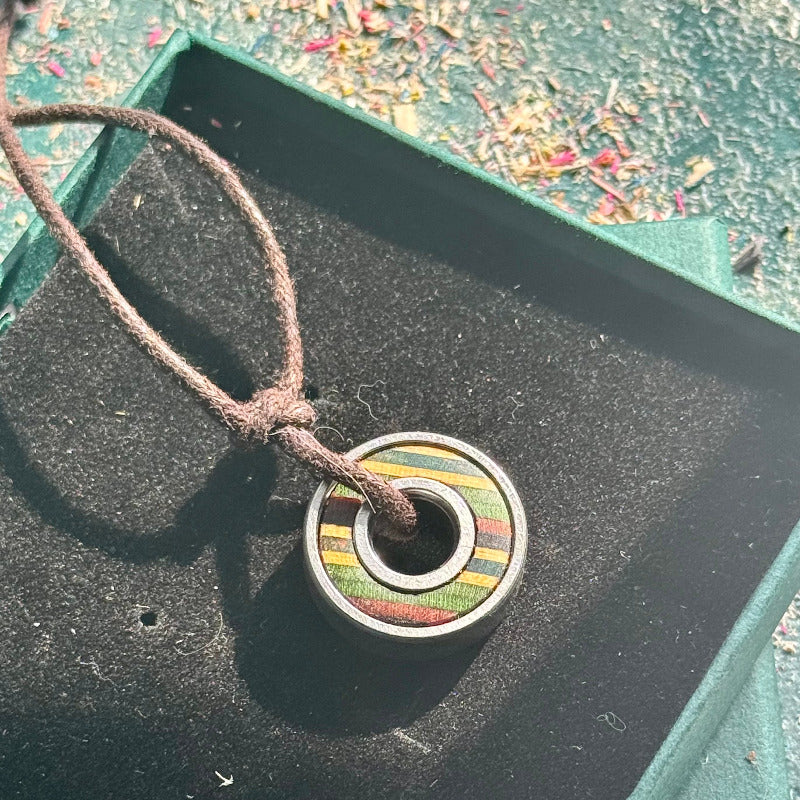 Necklace with a colorful pendant on a black surface