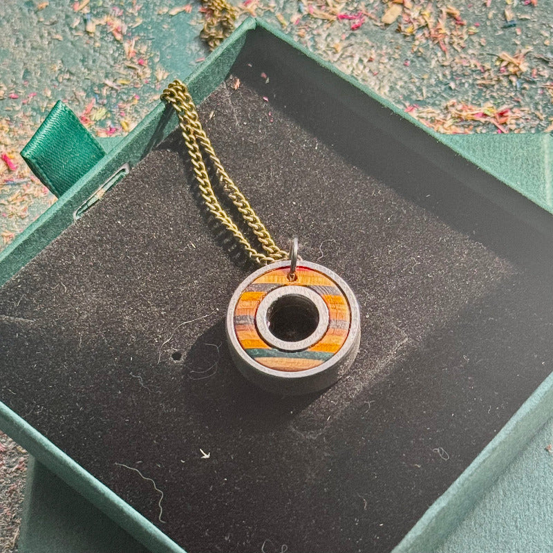 Wooden pendant with a chain on a textured surface