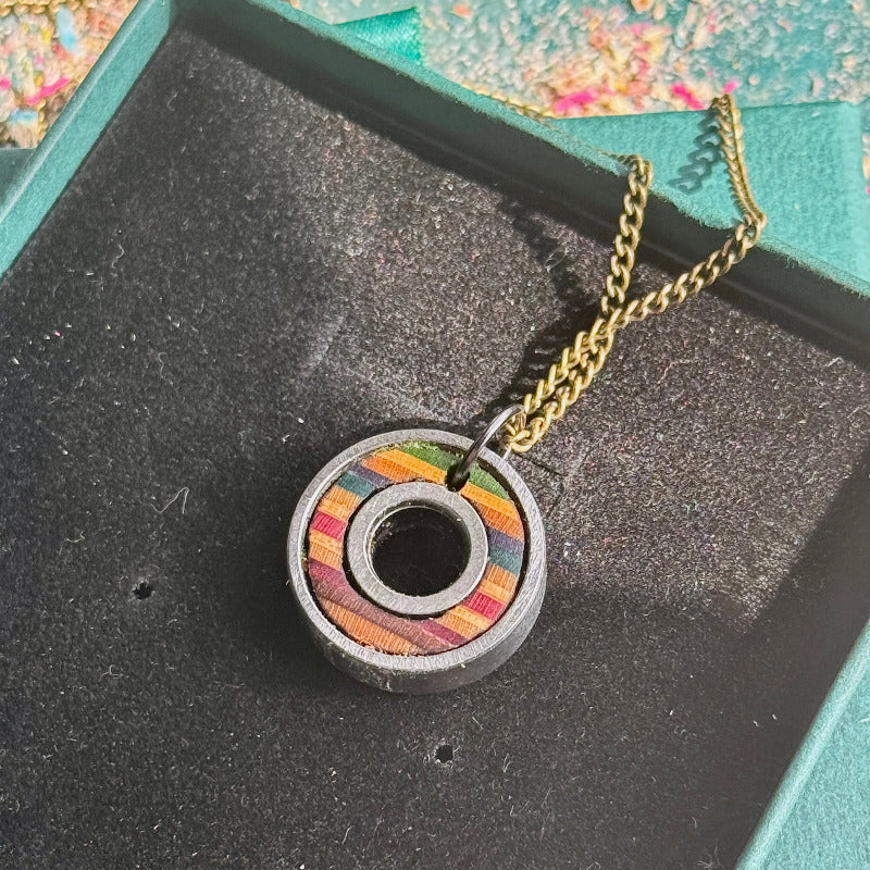 Necklace with a colorful pendant on a black surface