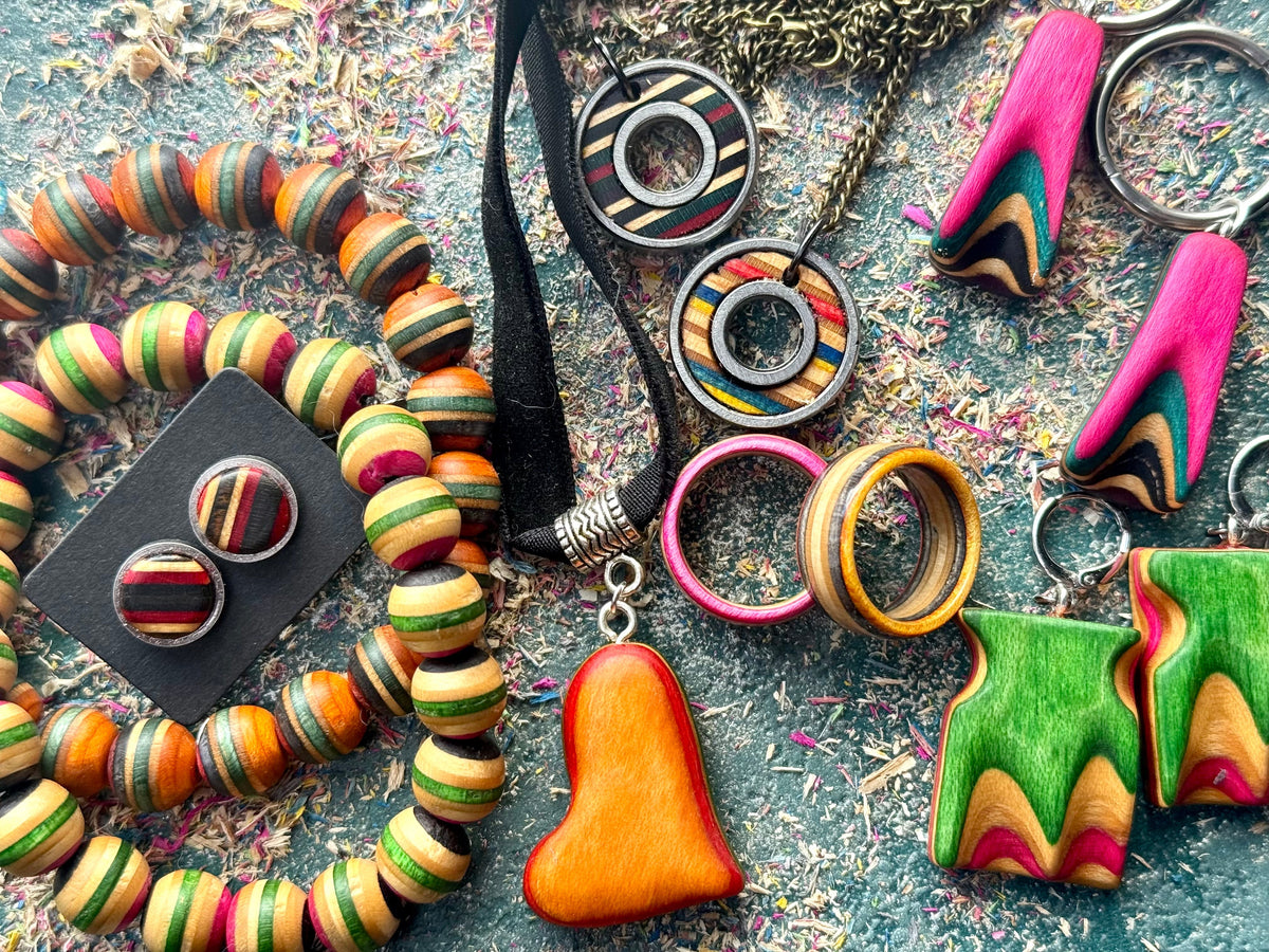 Skateboard wood jewellery laid out together: bead bracelets, bearing pendants, rings, stud earrings and keyrings