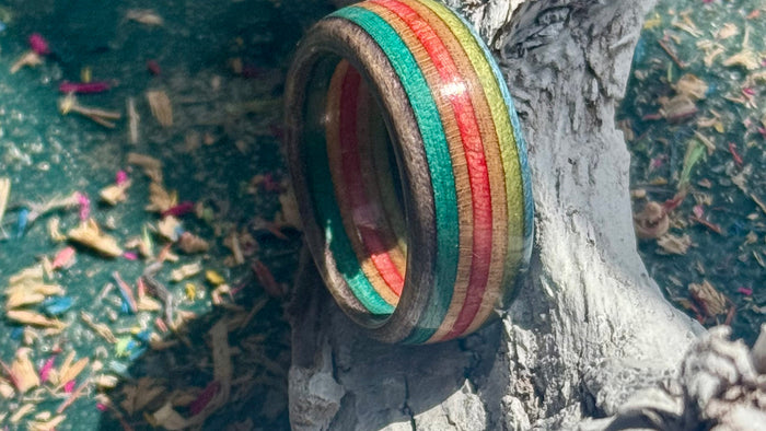 Red, blue and green recycled skateboard ring showing the layered maple inside the band