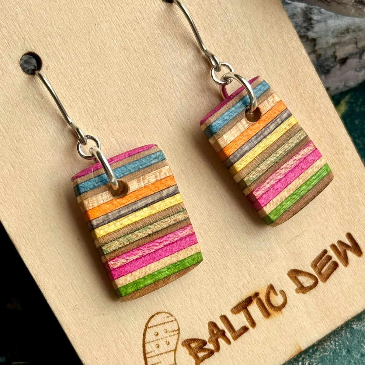 Close view of pink, orange, yellow and green deck stripes in recycled skateboard maple, by Baltic Dew