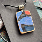 Recycled skateboard wood pendant with a blue face, orange disc and natural maple edges.
