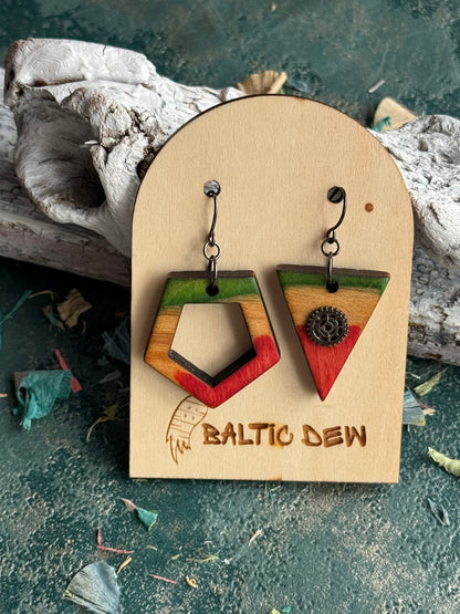 Mismatched skateboard wood earrings, a green pentagon outline paired with a red triangle