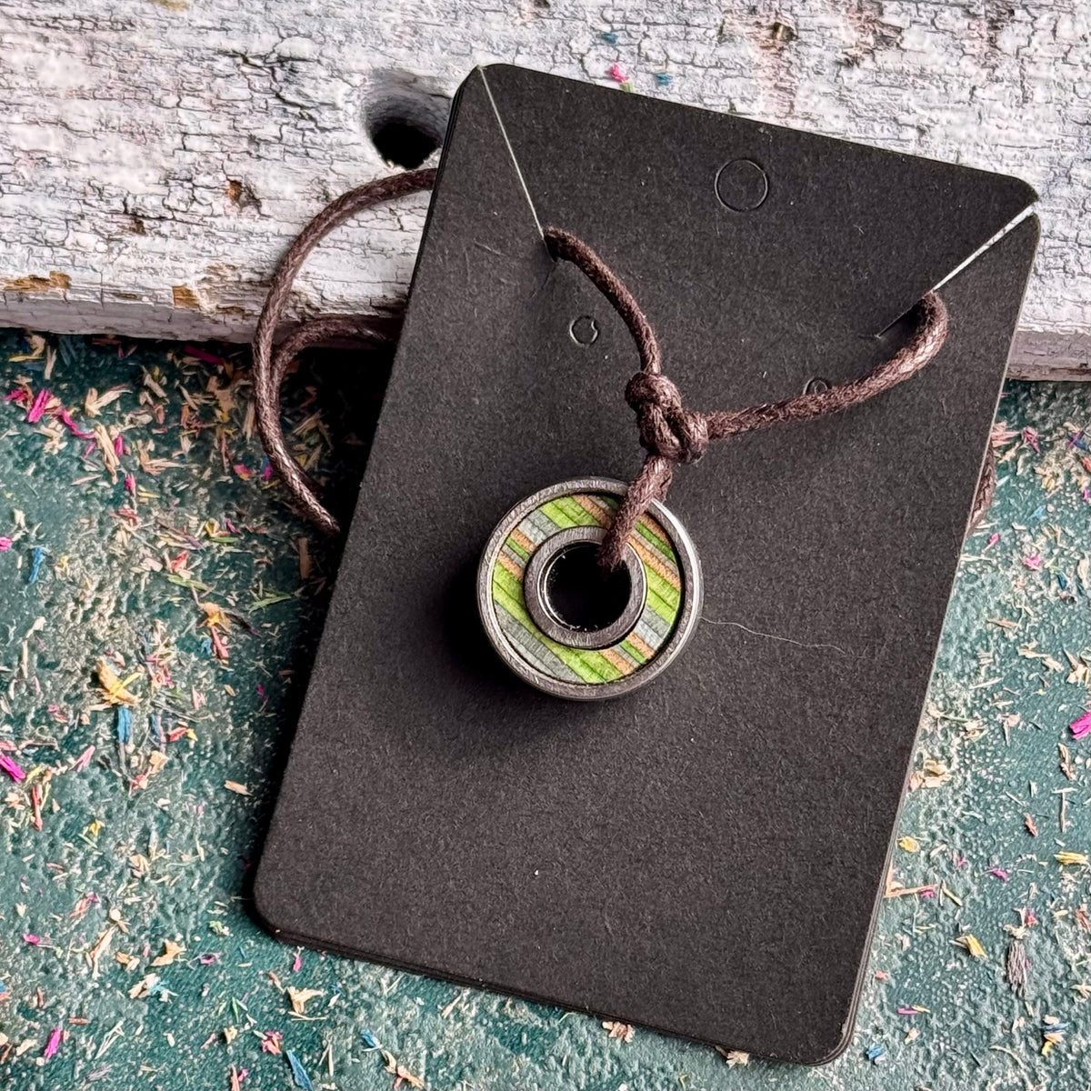 Skateboard bearing pendant necklace in green and blue recycled skateboard maple, handmade by Baltic Dew.
