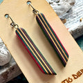 Close view of pink, teal and purple striped skateboard wood long drop earrings, handmade by Baltic Dew