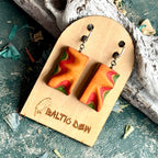 Orange, red and green carved skateboard wood earrings with a soft curved wave across the face
