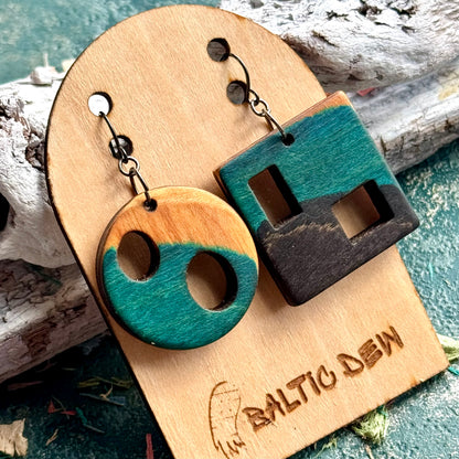 Mismatched teal skateboard wood earrings, a pierced disc paired with a slotted square