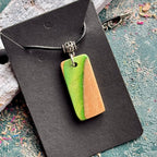 Recycled skateboard wood pendant showing the green deck layer against the natural maple grain.