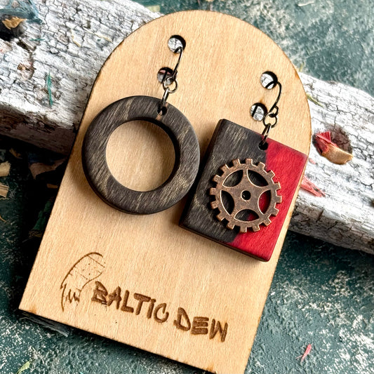 Mismatched skateboard wood earrings, a charcoal ring with a red square carrying a brass cog