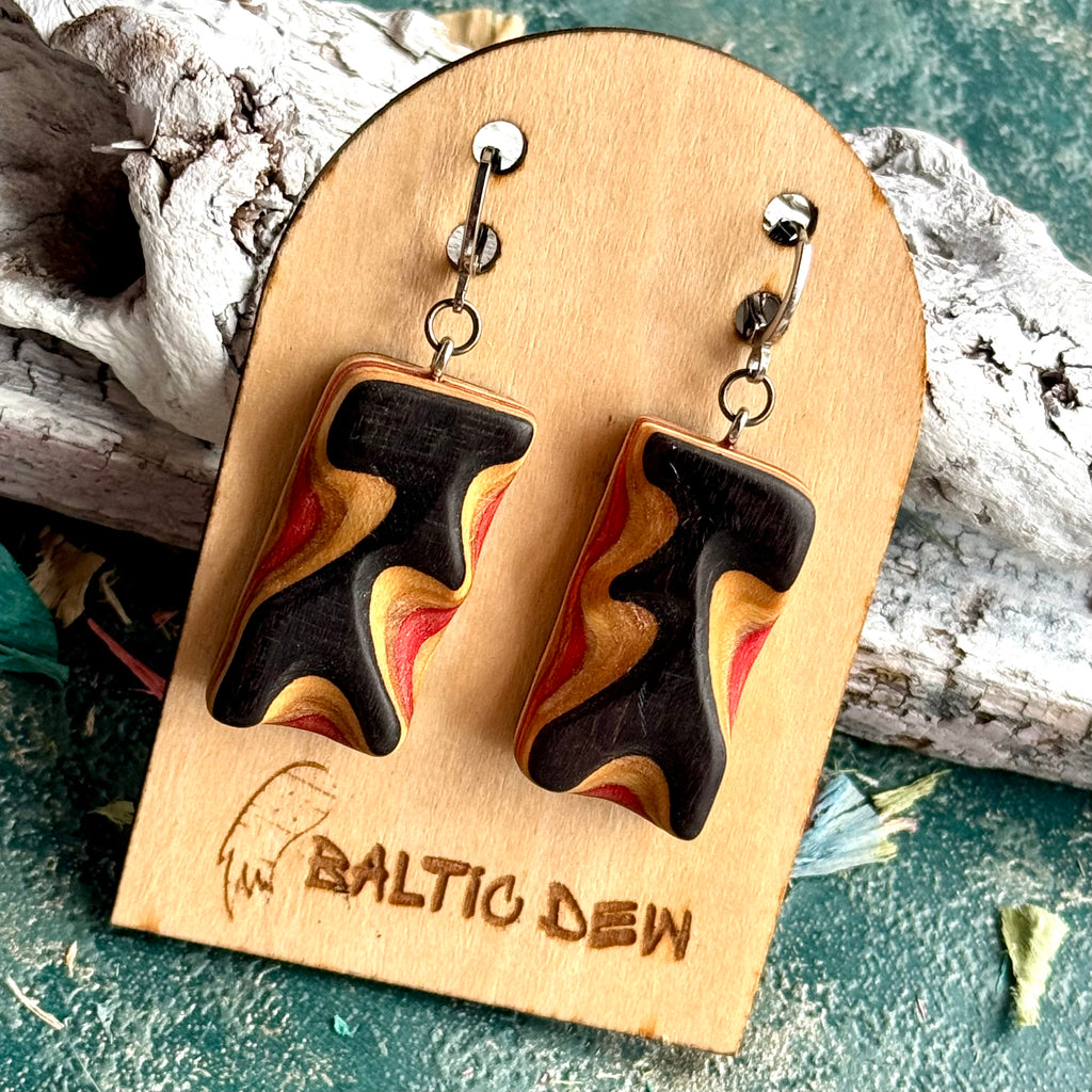 Black carved skateboard wood earrings with red, yellow and cream bands running across