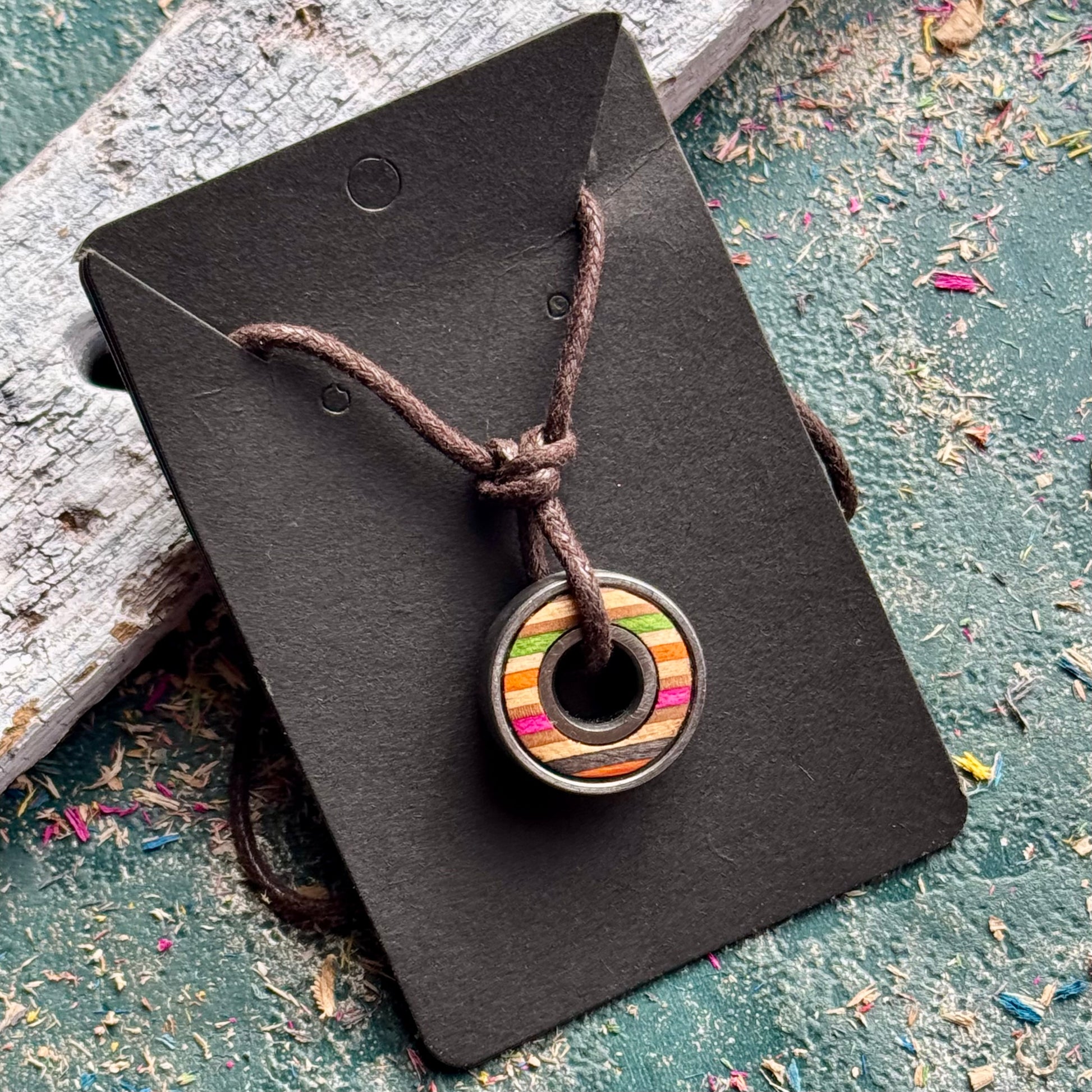 Multicoloured skateboard bearing pendant necklace in recycled skateboard maple, handmade by Baltic Dew.