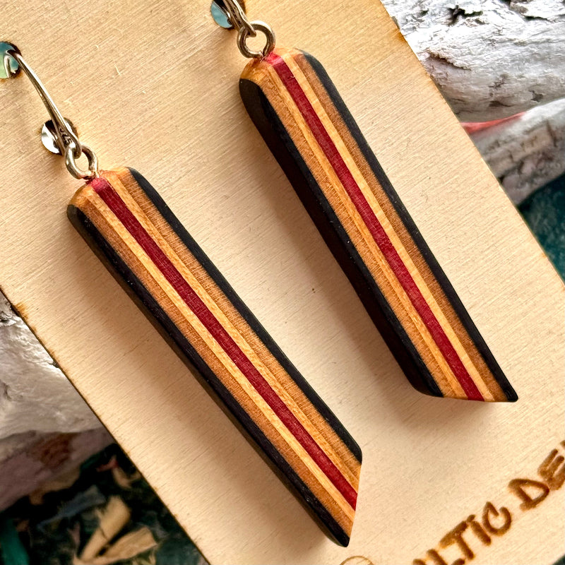 Close view of black and red striped skateboard wood long drop earrings, handmade by Baltic Dew
