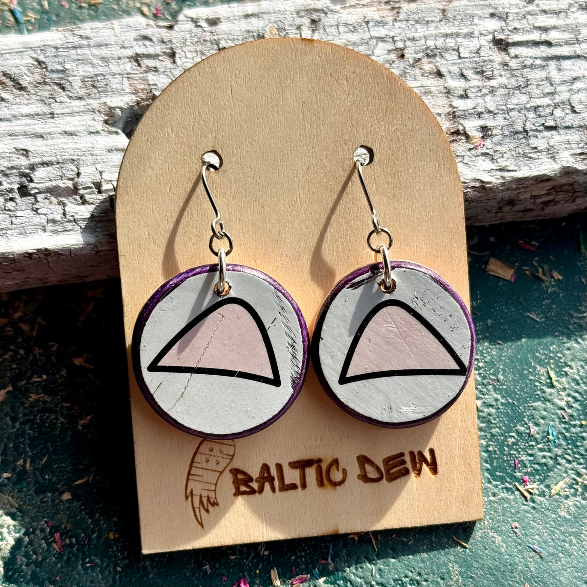 Round white and pink cat ear skateboard wood earrings on surgical steel hooks, shown on a card