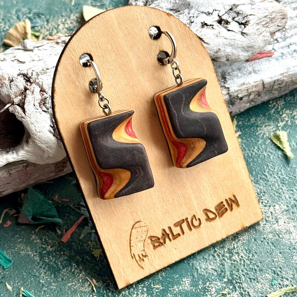Black carved skateboard wood earrings with a red and yellow flame shape in the layers