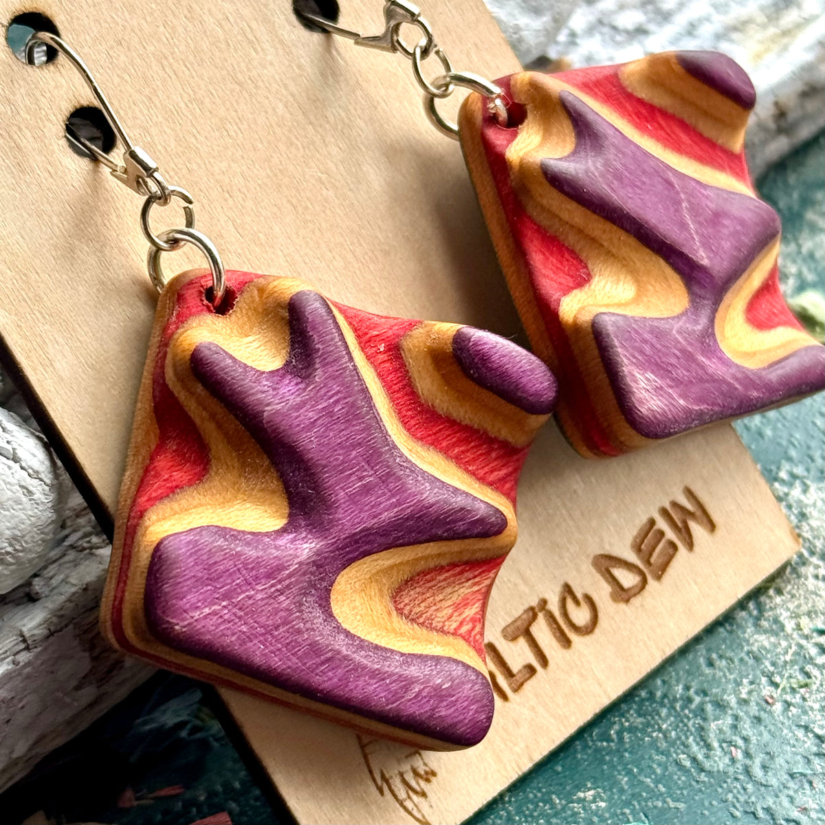 Close view of purple and red carved contours in recycled skateboard maple