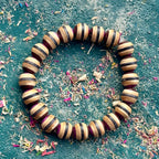 Purple, brown and black striped maple beads from a recycled skateboard deck, strung on elastic cord.