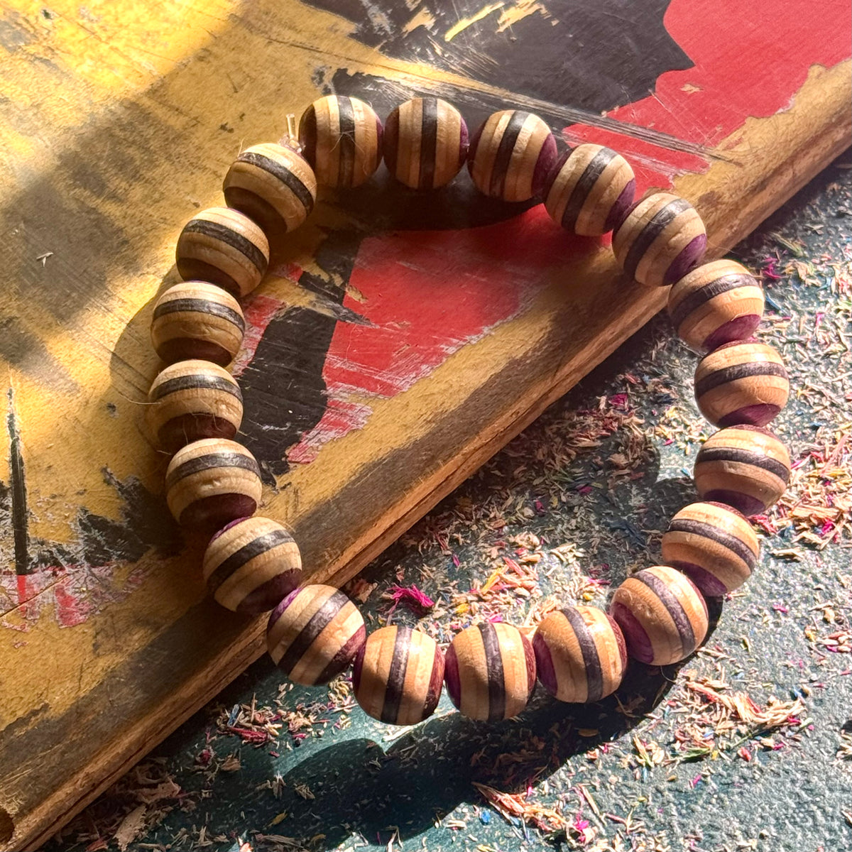 Purple, brown and black recycled skateboard maple bracelet on a yellow and red deck, handmade by Baltic Dew.