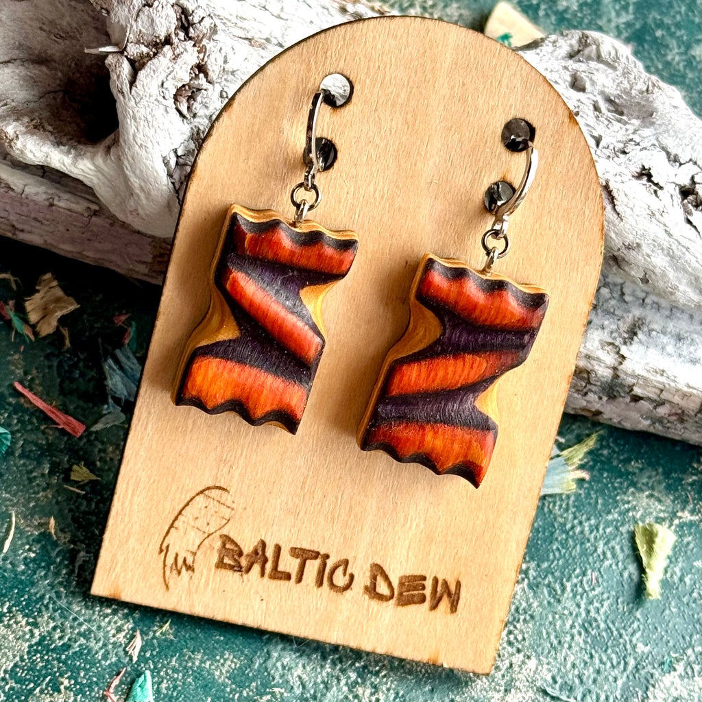 Orange and dark purple carved skateboard wood earrings with a zigzag through the layers