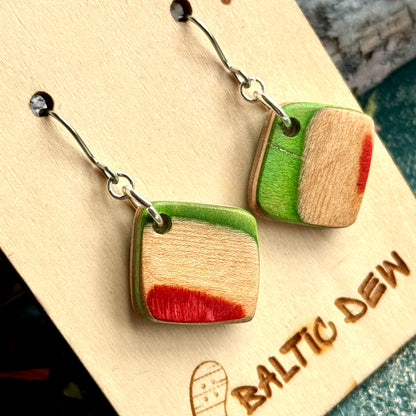 Close view of a green and red colour block square earring cut from recycled skateboard maple