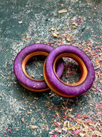 Pair of purple skateboard wood tunnels with natural maple showing around the bore.