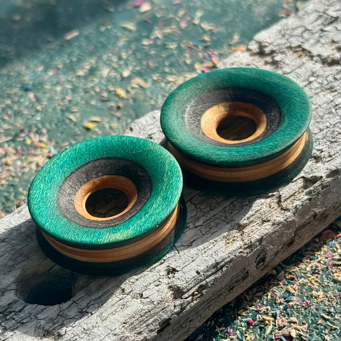 Deep green skateboard-wood tunnels on weathered timber, striped maple layers on show.