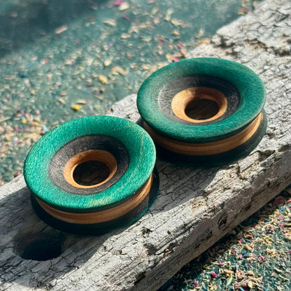 Deep green skateboard-wood tunnels on weathered timber, striped maple layers on show.