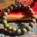 Wooden bead bracelet cut from a recycled skateboard deck, with green, teal and brown layers on every bead.