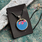 Blue and pink flower pendant cut from a recycled skateboard deck, handmade by Baltic Dew.
