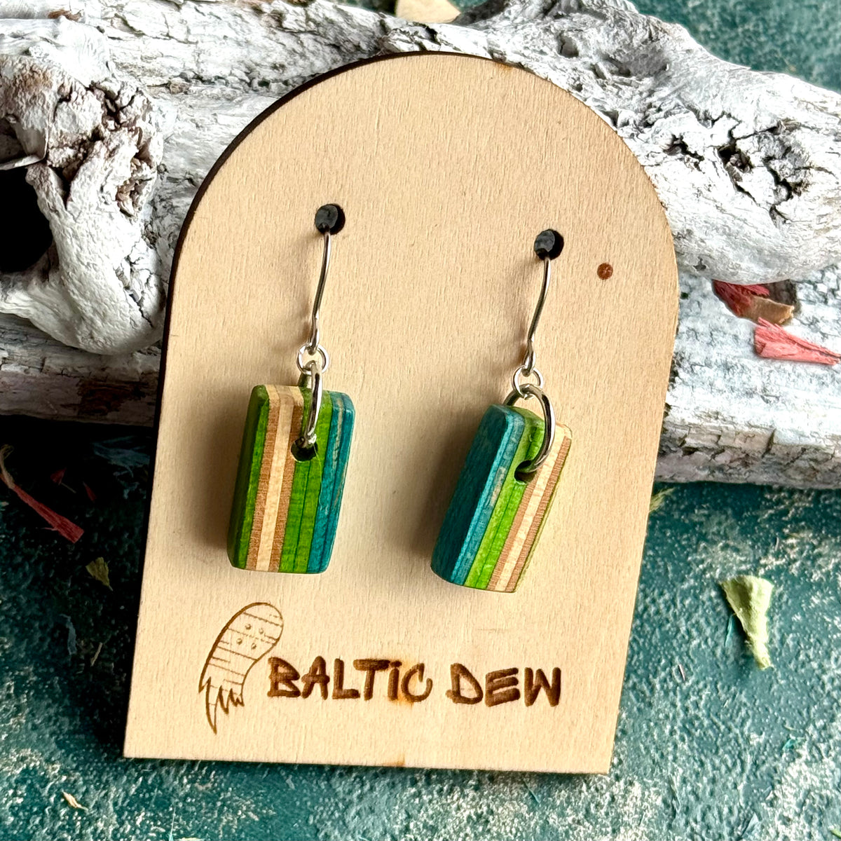 Small green and teal striped drop earrings with the skateboard deck layers running vertically