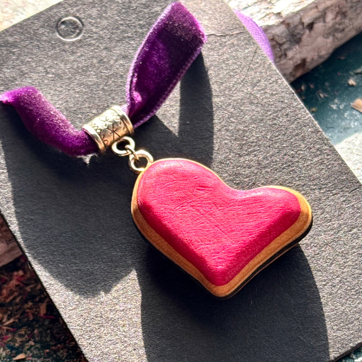Pink heart pendant in recycled skateboard maple on a purple velvet choker, handmade by Baltic Dew.