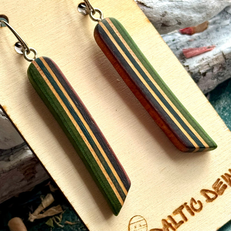 Close view of green, teal and brown striped skateboard wood long drop earrings, by Baltic Dew