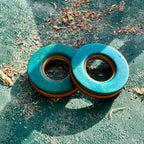 Bright blue and teal tunnels hand shaped from recycled maple ply, resting in sunlight.