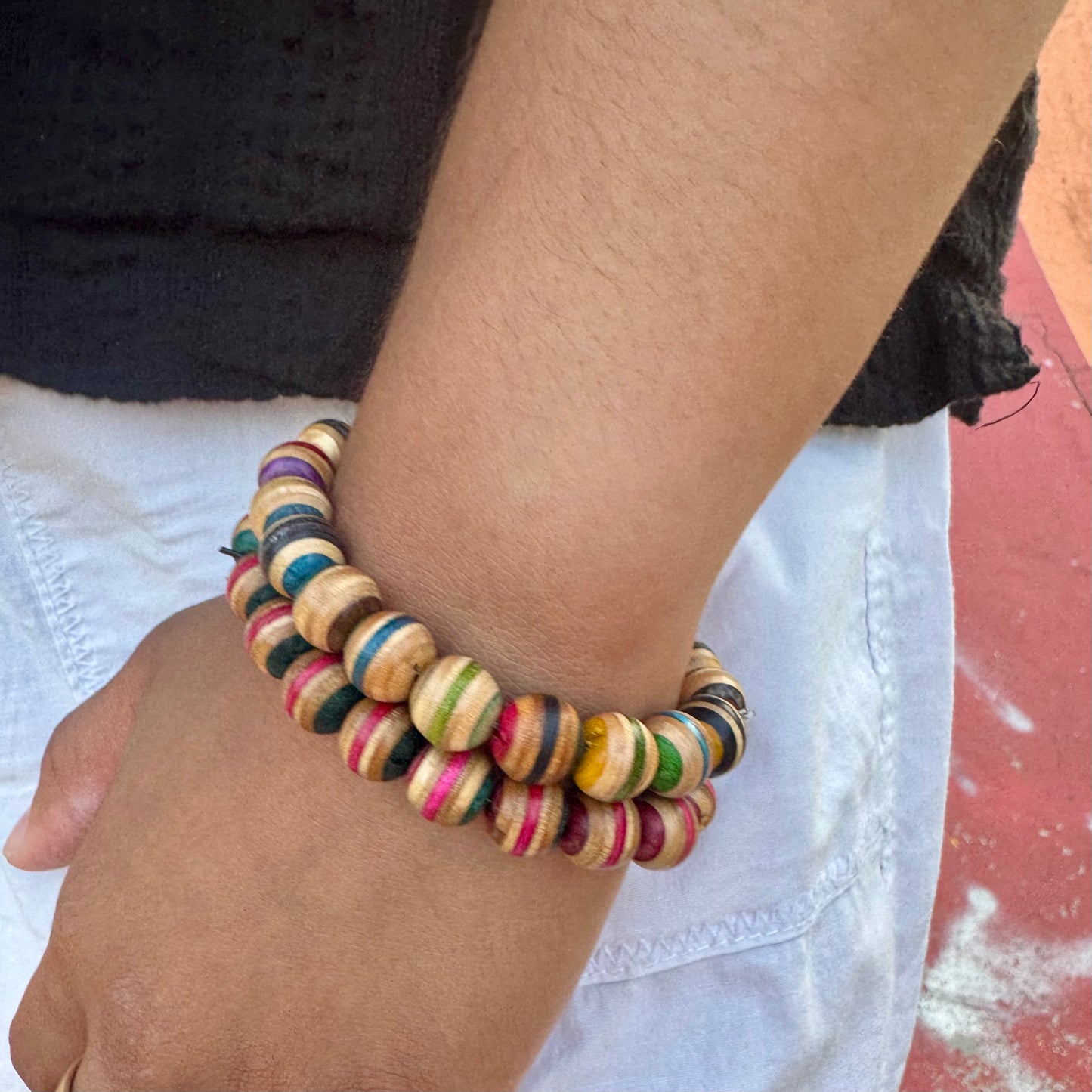 Recycled skateboard wood beaded bracelet worn on the wrist, striped maple beads in mixed colours