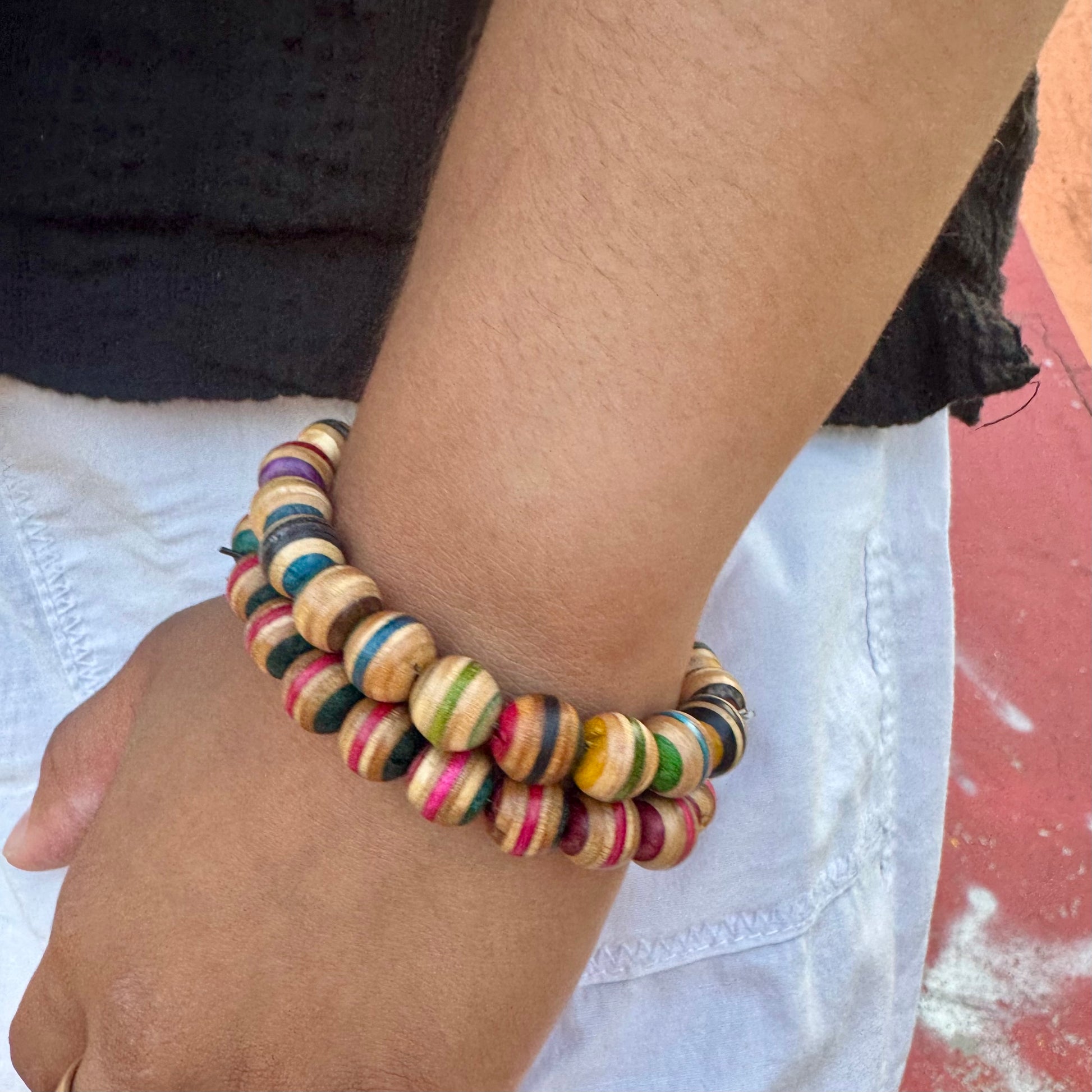 Recycled skateboard wood beaded bracelet worn on the wrist, striped maple beads in mixed colours