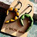 Reversible recycled skateboard wood spiral earrings showing the yellow and the green side together