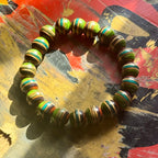 Green, teal and brown striped maple beads from a recycled skateboard deck, strung on elastic cord.