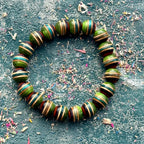 Bead bracelet cut from a recycled skateboard deck, green, teal and brown layers in every maple bead.