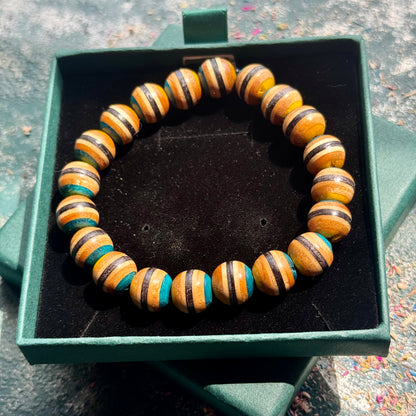 Yellow and Blue Skateboard Bracelet made of round wooden beads with alternating yellow, blue, and natural wood stripes displayed in a green box